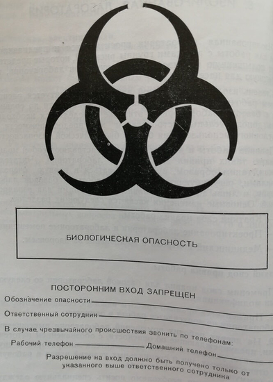 Знак на лабораторных дверях, предупреждающий об опасности